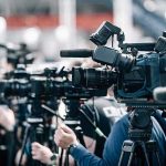 Deadly Shaking Week — One Shocking Exception Broadcast cameras on tripods at a press event
