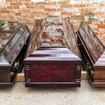 Three wooden coffins arranged outdoors