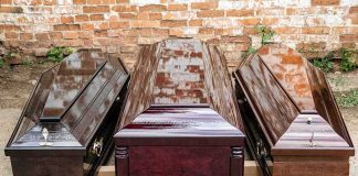 Three wooden coffins arranged outdoors