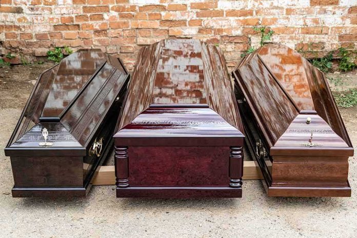 Three wooden coffins arranged outdoors