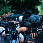 Hormuz Meltdown: Oil Route Becomes Kill Zone TV news cameras crowding together at an outdoor event