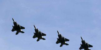 Four fighter jets flying in formation against a clear sky
