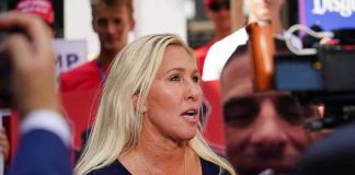 Blonde woman speaking to media at an outdoor event