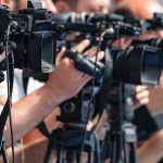 AI Power Grab: Nvidia Targets Open Hub television cameras on tripods at a media event