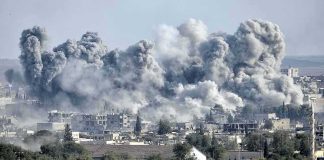 Massive smoke plumes rise over a city after explosions