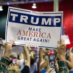 Shocking 99% Wins—What’s Missing? Crowd holding a political rally sign