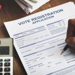 Person filling out a voter registration application form