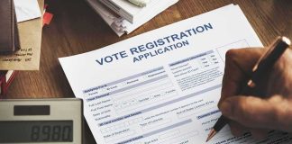 Person filling out a voter registration application form