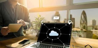 Laptop on desk showing cloud network icons