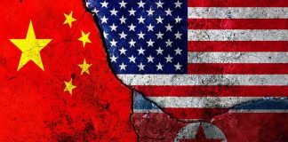 Composite of China, United States, and North Korea flags on cracked wall