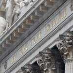 Facade of the New York Stock Exchange featuring sculptures and gold lettering