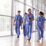 Code Demands Activism From Nurses Group of healthcare workers walking in a bright hospital corridor