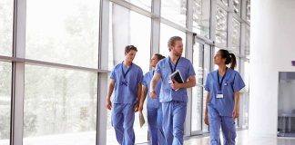 Group of healthcare workers walking in a bright hospital corridor