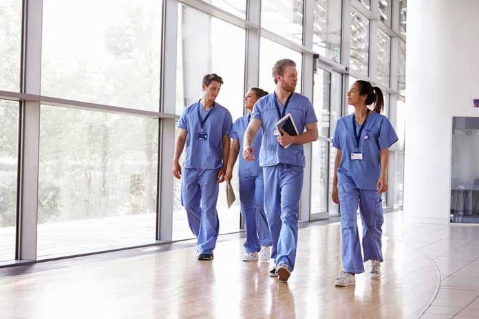 shutterstock_737467600 Group of healthcare workers walking in a bright hospital corridor
