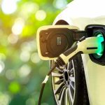 Electric car charging port with plugged-in cable