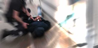 person being restrained on the ground in a hallway
