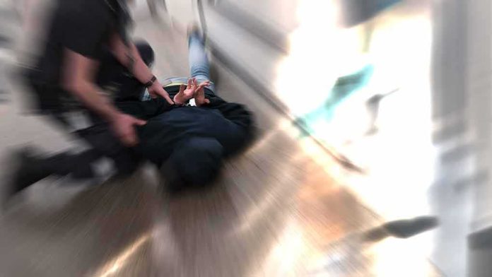person being restrained on the ground in a hallway