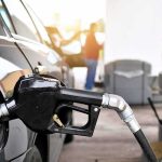 Trump Unleashes $8B Harvest Cash Surge Gas pump nozzle fueling a black car at a station