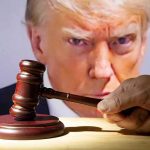 gavel held by a hand in front of a large projected face