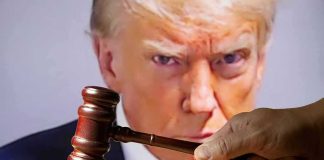 gavel held by a hand in front of a large projected face