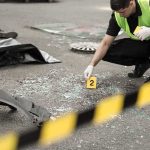 Detroit Marathon Rocked By Sudden Loss Forensic investigator marking evidence at crash scene