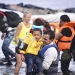44 Dead as Massive Floods Sweep Across Thailand man carries child wearing life jacket at shoreline