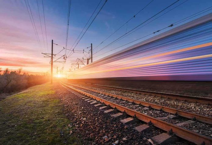 High-speed train passing on railway tracks at sunset