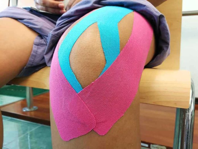 shutterstock_659417128 Knee with colorful kinesiology tape applied